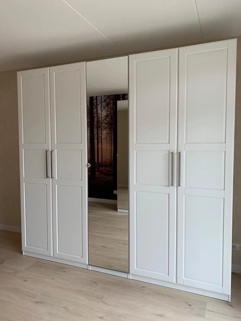 PAX kledingkast met frosted-glass schuifdeuren in een Nederlands interieur